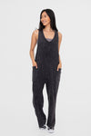 Balance Mineral Washed Lounge Jumpsuit. Mono B brand mineral washed jumpsuit features a soft cotton textured fabric with a vintage look, v neckline with wide straps that are joined with a center knot detail at the back, and finished with large patch pockets.