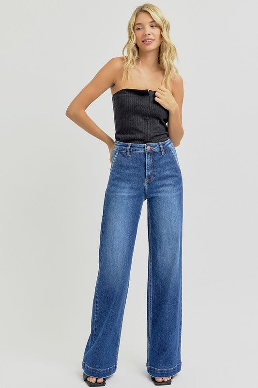 RISEN High Rise Wide Leg Slanted Pockets Jeans. Medium wash stretch denim designed with a high rise, wide leg silhouette, slanted front pockets, and finished with a trouser hem.