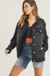 RISEN Black Vintage Wash Oversized Denim Jacket. Vintage wash black denim jacket with distressed details, button down front, button cuffs, front button pockets, additional side pockets, and a relaxed fit.