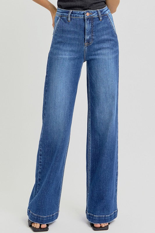 RISEN High Rise Wide Leg Slanted Pockets Jeans. Medium wash stretch denim designed with a high rise, wide leg silhouette, slanted front pockets, and finished with a trouser hem.