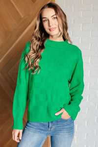 Featuring a round ribbed neckline, sleeve cuff, and hemline. This cheery green knit top with a subtle monochromatic checkered pattern will brighten up a cold winter day!