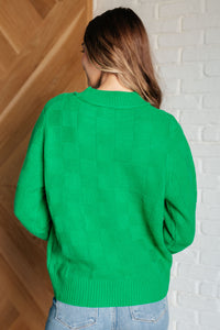 Featuring a round ribbed neckline, sleeve cuff, and hemline. This cheery green knit top with a subtle monochromatic checkered pattern will brighten up a cold winter day!