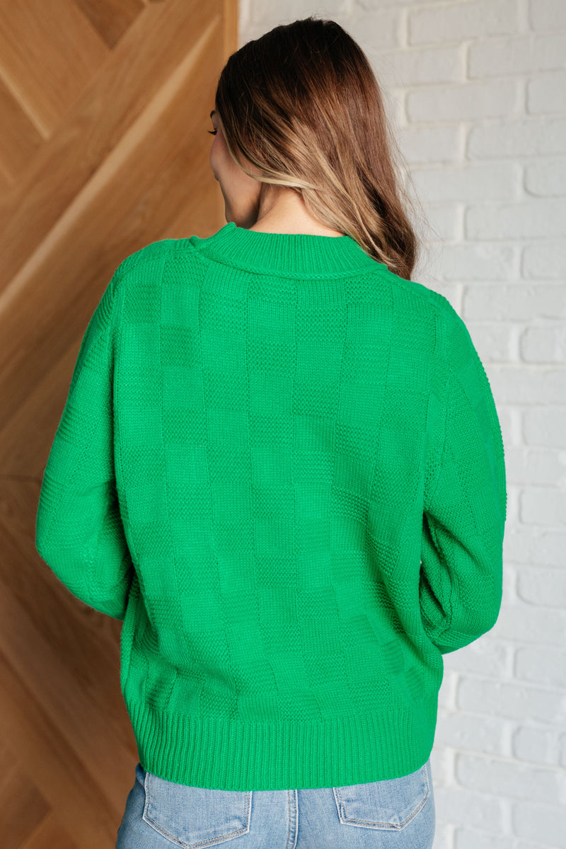 Featuring a round ribbed neckline, sleeve cuff, and hemline. This cheery green knit top with a subtle monochromatic checkered pattern will brighten up a cold winter day!