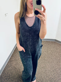 Balance Mineral Washed Lounge Jumpsuit. Mono B brand mineral washed jumpsuit features a soft cotton textured fabric with a vintage look, v neckline with wide straps that are joined with a center knot detail at the back, and finished with large patch pockets.