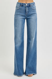 Risen High Rise Tummy Control Wide Leg Jeans. These medium wash jeans are designed with a mid-rise, wide leg silhouette, front seam detail, and front patch pocket design.