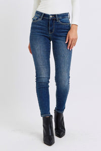 Judy Blue Mid Rise Thermal Skinny Jeans. Featuring Judy Blue stretch denim with a brushed thermal interior for an extra layer of warmth. Designed with a mid rise, dark wash, stitching on the back pockets, and no distressing.