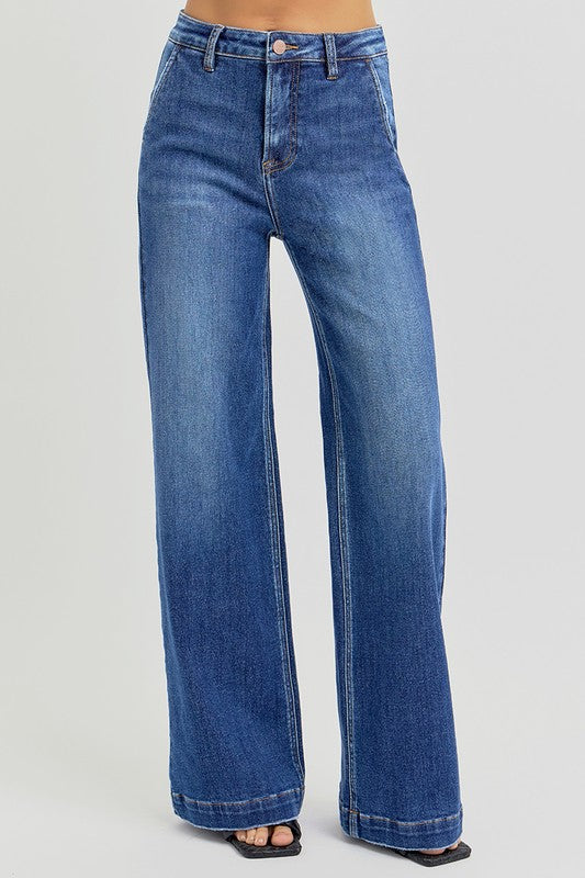 RISEN High Rise Wide Leg Slanted Pockets Jeans. Medium wash stretch denim designed with a high rise, wide leg silhouette, slanted front pockets, and finished with a trouser hem.