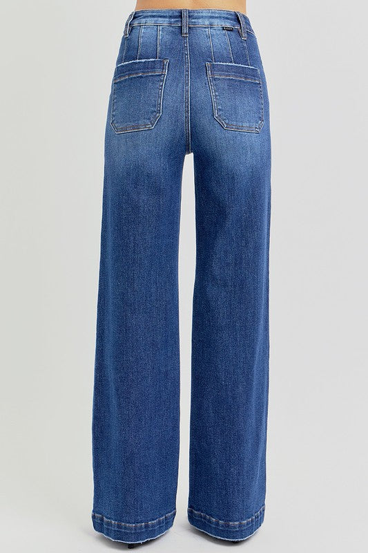 RISEN High Rise Wide Leg Slanted Pockets Jeans. Medium wash stretch denim designed with a high rise, wide leg silhouette, slanted front pockets, and finished with a trouser hem.